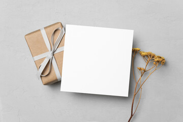 Square paper card mockup with gift box and dry flowers