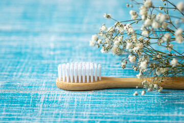 Natural eco-friendly bamboo toothbrush on a blue background, copy space.
