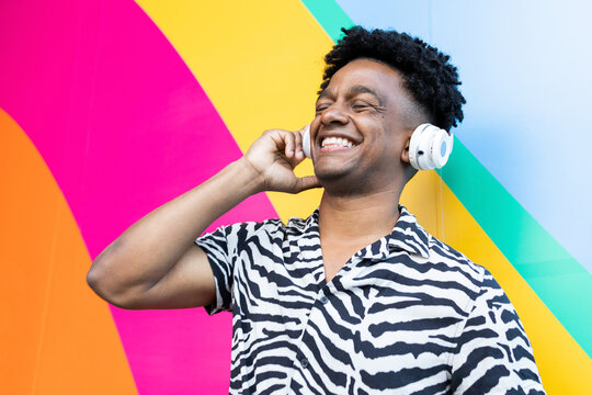 Excited ethnic man listening to music