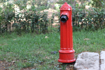 Fototapeta na wymiar Fire hydrant, fireplug, or firecock on a street side. It is a connection point by which firefighters can tap into a water supply