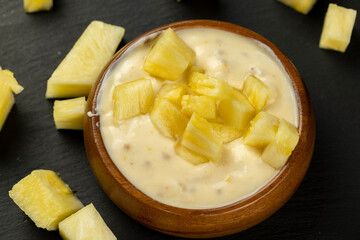 milk pineapple yogurt with pieces of pineapple and other fruits