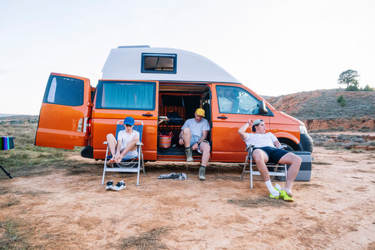 Group of campers sitting outside mobile van house