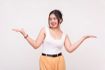 Fototapeta na wymiar A happy young Asian woman with braces casually shrugging while looking to the left at her palm. Isolated on a white background.