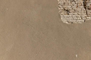 Part of the building wall with damaged plaster