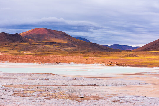 Frozen lagoon surrounded by hills in Piedras Rojas park in Atacama desert