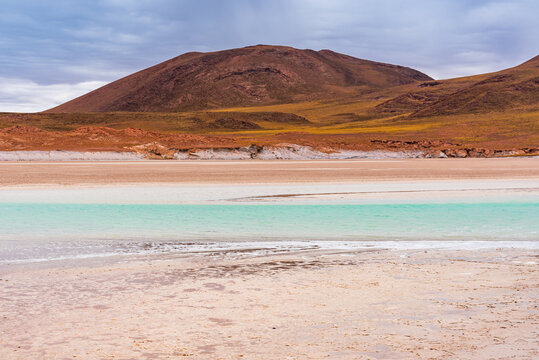 Colorful lagoon under a hill in Atacama desert