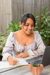Smiling latin woman using laptop
