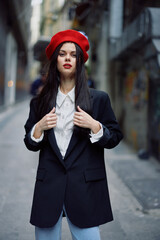 Fashion woman portrait walking tourist in stylish clothes with red lips walking down narrow city street, travel, cinematic color, retro vintage style, dramatic look without smile sadness.