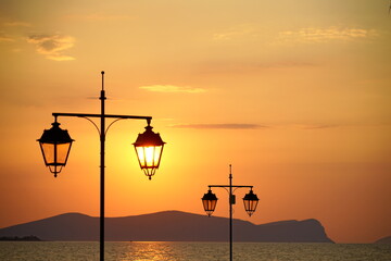 Sunrise over the Aegean sea with streetlights - 617118967