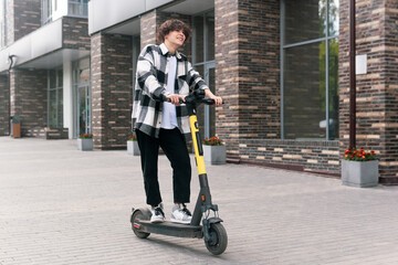 young man on an electric scooter rides down the street © Evgeny