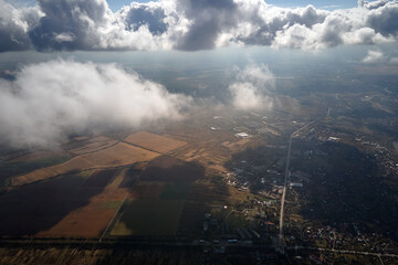 Obraz premium Aerial view from airplane window at high altitude of earth covered with white puffy cumulus clouds