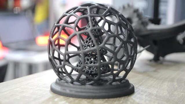 Abstract art object Christmas tree in ball printed on 3D printer from polyamide powder. Three-dimensional model created by 3D printer on table in office. MJF Multi Jet Fusion. 3D printing technology