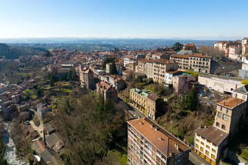 Fototapeta na wymiar Aerial view of dense historic center of Thiers town in Puy-de-Dome department, Auvergne-Rhone-Alpes region in France. Rooftops of old buildings and narrow streets