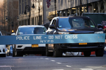 Police line, do not cross NYPD wooden police barricade on Midtown Manhattan street with car traffic