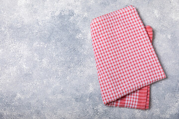Kitchen towels on a marble background. New kitchen cotton towels on the kitchen table. Red checkered picnic napkin. Home textiles. Place for text. copy space.