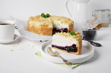 A pies of cottage cheese pie with crumbs and filler from frozen berries and mint and cup of tea. Seasonal food