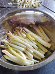 Fresh organic asparagus, washed and peeled, in a metal dish, ready for cooking