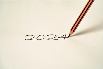 The new year 2024 is sketched on a white surface with a pencil.