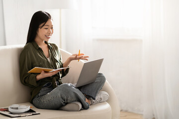 Asian woman student attending webinar from home, using laptop