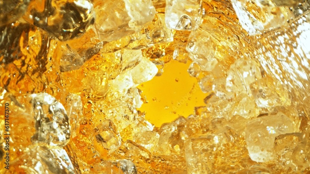 Aufkleber Texture of splashing whiskey surface with ice cubes.
