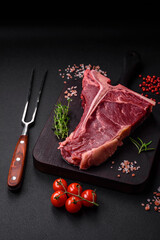 Raw juicy beef t-bone steak with salt, spices and herbs