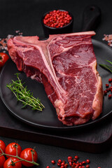 Raw juicy beef t-bone steak with salt, spices and herbs