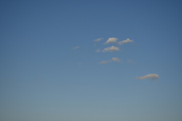 Clear blue skies with fluffy white clouds, white cloud against a blue summer sky, summer lonely clouds against a soft blue summer sky