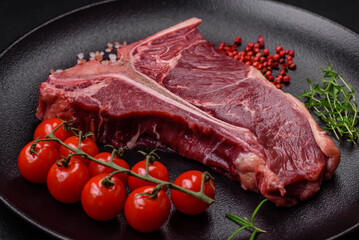 Raw juicy beef t-bone steak with salt, spices and herbs