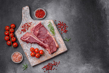 Raw juicy beef t-bone steak with salt, spices and herbs