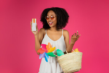 Smiling millennial black woman student in sunglasses enjoy vacation, show jar of sun cream