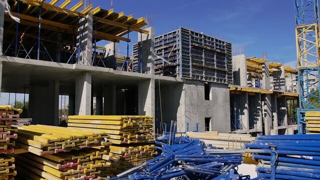 View of the construction site with the walls of the house and the composition of metal beams, supports, columns and other building materials.