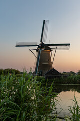 Beautiful wooden windmills at sunset in the Dutch village of Kinderdijk. Windmills run on the wind. The beautiful Dutch canals are filled with water. Beautiful sunset. - 617150745