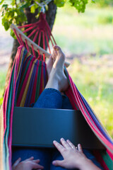 freelance.
work from home
with a laptop on vacation.woman with a laptop on a hammock.working in pleasure.colorful hammock.outdoor recreation.playful girl.lying on a hammock.resting in nature.relax