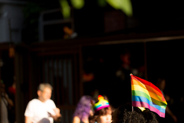Bandeirolas símbolo do orgulho gay nas mão de vendedores ambulantes na  27ª edição, da Parada do Orgulho LGBT+ de São Paulo, Avenida Paulista, Brasil.  - obrazy, fototapety, plakaty