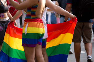 Jovens vestidos com com roupas com as cores da bandeira que simboliza o orgulho gay. 27ª edição, da Parada do Orgulho LGBT+ de São Paulo, Brasil.  - obrazy, fototapety, plakaty