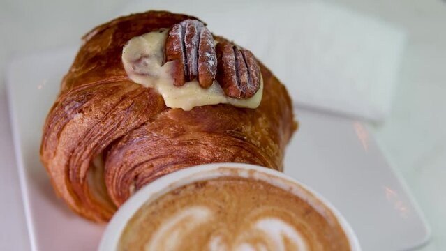 Cinemagraph - top view of served breakfast. Appetizing crunchy croissants with hot coffee, raspberries and walnuts. High quality 4k footage