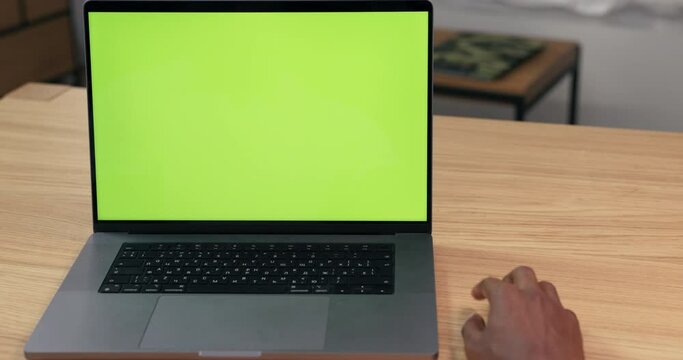A man sits in front of his laptop ready to work and waits for the computer to turn on, a page to load, slow internet, the guy's impatience causes him to slap hand on the table in anticipation.