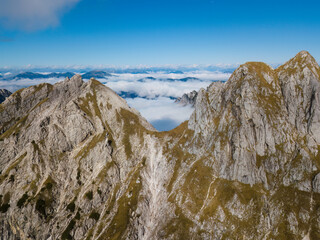Rocky mountains rising above clouds. Photo taken with a drone. Julian Alps, Slovenia.