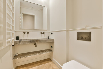 a bathroom with white walls and wood flooring on the wall, there is a mirror hanging above the sink