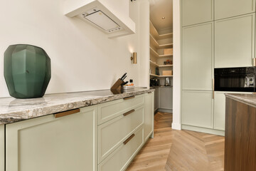 a modern kitchen with marble counter tops and white cabinets in the room is well lit by the light coming through the window
