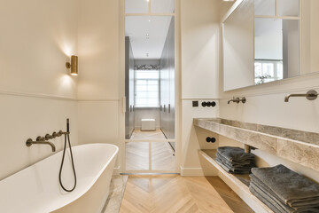 a modern bathroom with wood flooring and marble countertops on the walls, along with a freestanding...