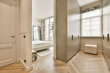 a bedroom with white walls and wood flooring in the middle of the room, there is a mirror on the...