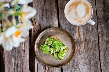 toast with lettuce, avocado, black sesame. homemade bread. Top view. Wooden background.
