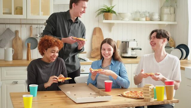 Home party. Overjoyed diverse friends eating ordered pizza for home party. Happy group mixed race young buddies enjoying spending free weekend time together having fun laughing joking communicating