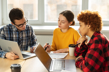 Teamwork brainstorm. Diverse colleagues working together discuss financial statistics. Group of happy young modern people sitting in creative office discussing business. Young professional team