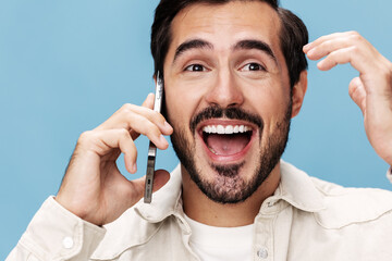 Close-up portrait of a brunette man talking on the phone, smile with teeth open mouth happiness, on...