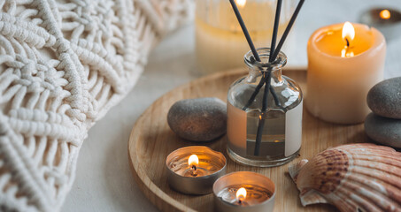 Cozy corner for home meditation and relaxation. Aroma diffuser, burning candles, stones for comfort, pleasure, aromatherapy. Decor for apartment, house, indoors design. Banner