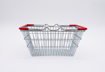 Photo of an empty silver metal wire shopping basket with red handles 