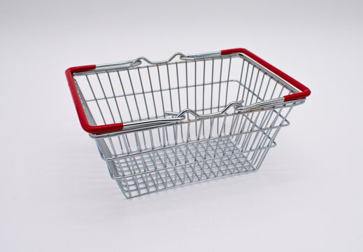 Photo of an empty silver metal wire shopping basket with red handles 