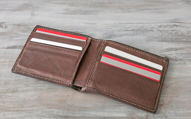 Stylish men's purse with credit cards on wood background.